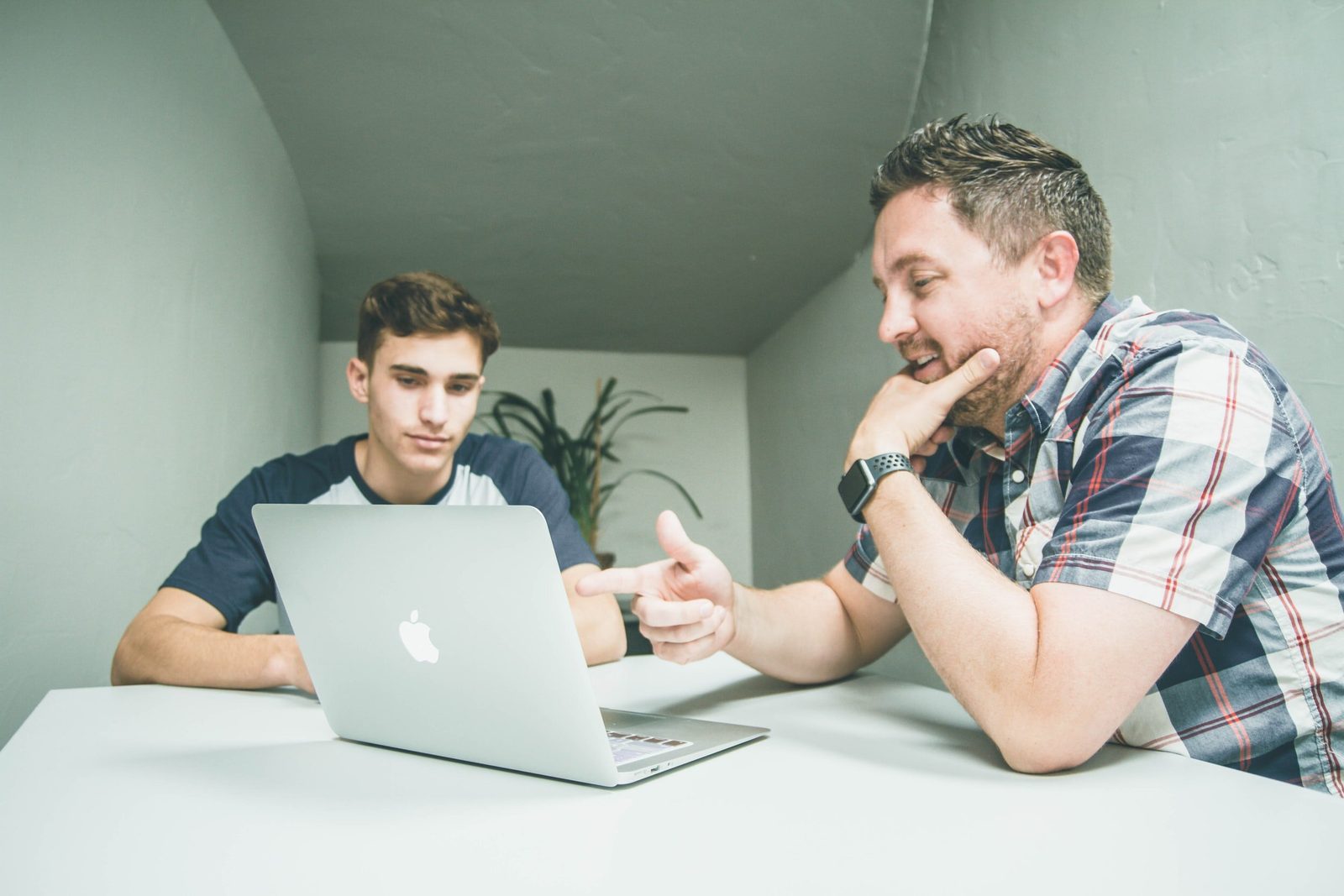 Two people working through something together at a laptop